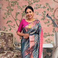 Front view of blue-green printed Litchi silk saree with pink blouse in palace setting