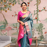 Front view of blue-green printed Litchi silk saree with pink blouse in palace setting