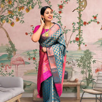 Front view of blue-green printed Litchi silk saree with pink blouse in palace setting