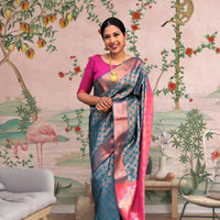 Front view of blue-green printed Litchi silk saree with pink blouse in palace setting