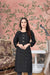 Front view of black rayon kurti against grey brick background
