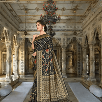 Close-up of golden abstract zari motifs on black Banarasi silk inside palace room