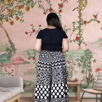  Rear silhouette of palazzo revealing gathered drape in motion