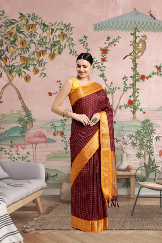 Woman draped in coffee-colored saree standing gracefully