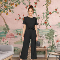 Front angle of black knitted cap sleeve jumpsuit with round neck – lifestyle background