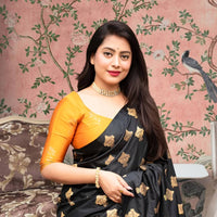  Front view of black silk saree with vibrant yellow blouse in royal palace room
