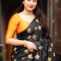 Front view of black silk saree with vibrant yellow blouse in royal palace room