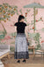 Rear profile of flared pants catching market breeze