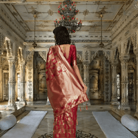 Zari pallu of maroon silk saree cascading in a regal palace room setting