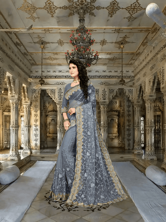 Grey net saree glowing under palace chandeliers, silver embroidery casting lace shadows