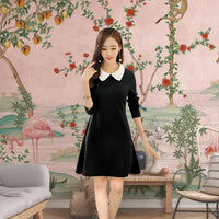 Model in monochrome dress with white collar – front view in Japanese-inspired setting