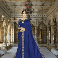 Model in navy blue silk blend saree with pink printed border in palace room
