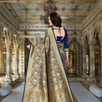 Elegant flow of gold pallu from blue silk saree in regal environment