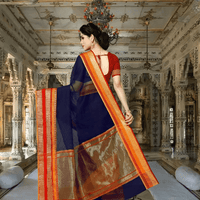 Poised portrait of woman in regal stance, golden pallu catching light with crimson edges