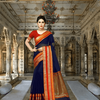 Model draped in navy saree walking through temple corridor, light glowing on golden borders