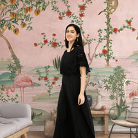 Right profile of black crepe gown in palace backdrop