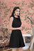 Side angle of Celestina’s sleeveless black polyester dress with round neck

