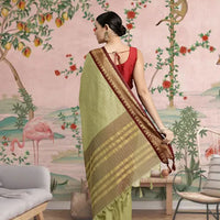 Rear view showing pallu fall in earthy olive tones