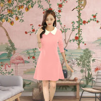 Model in peach monochrome dress with white collar – soft-toned palace backdrop