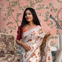  Front view of white-orange silk saree in a floral-themed palace backdrop