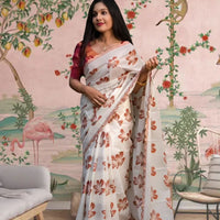 Front view of white-orange silk saree in a floral-themed palace backdrop