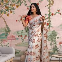 Front view of white-orange silk saree in a floral-themed palace backdrop