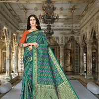 Close-up of pink floral designs on lush green Banarasi silk fabric