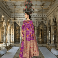 Close-up of blooming red-orange floral motifs inside golden grid on purple silk