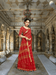 Model in red checkered saree glowing under golden palace lighting