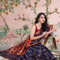  Front view of navy blue checkered saree radiating elegance in palace lighting