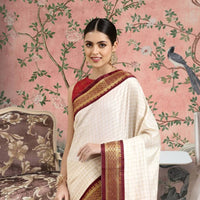 Front view of white checkered cotton silk saree with maroon border in regal setting