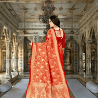 Pallu draping richly with gold zari on red Banarasi silk in heritage backdrop