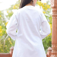 Back detail of band collar tunic, seams precise as a monk’s parchment folds, glowing in muted daylight