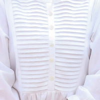 Garment arranged on aged paper, cotton mimicking cracked ivory relics
