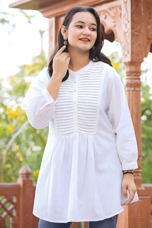  Front view of white tunic against stone chapel walls, fabric cascading like frozen breath in winter light