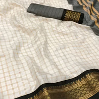  Studio close-up of black-gold border detail on soft white saree