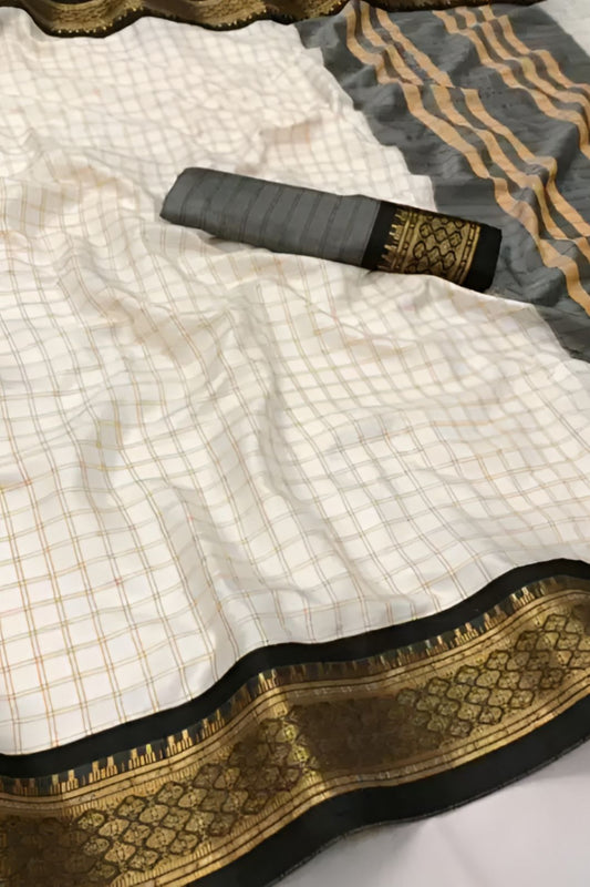  Studio close-up of black-gold border detail on soft white saree