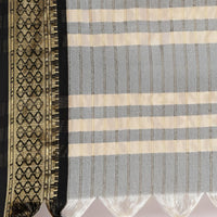 Close-up of the woven fabric with a checkered pattern and a decorative border.