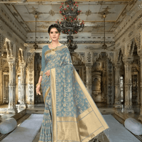Close-up of golden patterns on grey cotton saree inside palace room
