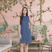  Front view of sleeveless denim dress against brick wall