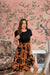  Front view of black and orange floral dress with short sleeves