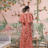 Back view of CELESTINA’s orange floral gown in royal setting