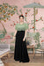  Front view of green-black sleeveless crepe gown in palace setting