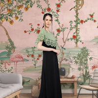 Left profile of green and black full-length crepe gown
