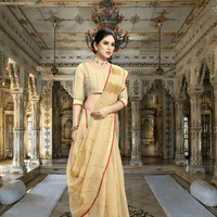 Model standing against sandstone pillar, beige saree catching sunlight like sacred dust