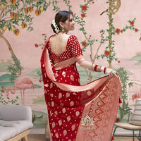  Back profile showcasing bold red pallu in ceremonial lighting